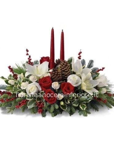 Composizione natalizia con fiori rossi e bianchi, candele e abete con altri devori.